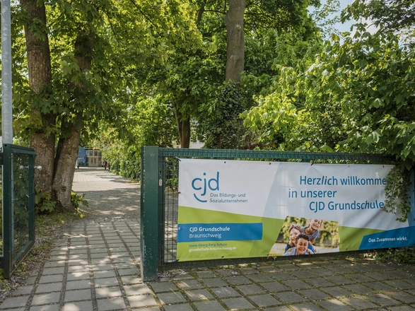 Schultor mit Banner Herzlich willkommen